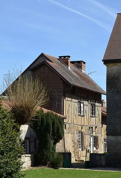 Foto von Haus mit Holzseiten gegenüber der Mitte der nördlichen Fassade der Kirche - Pline - © Creative Commons (https://creativecommons.org/licenses/by-sa/4.0/deed.fr)
