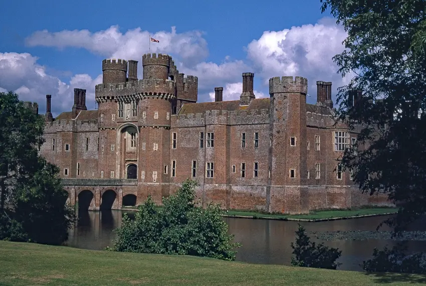 Photo de Château de Herstmonceux, avec des ponts attachés au nord et au sud et une chaussée avec des murs de soutènement à l'ouest. - Historic England / Graeme Wall