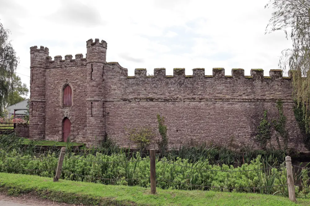 Photo de Grange sur le côté ouest de la cour de ferme et du mur de rideau qui entourerait la cour au château de Bollenree - Historic England